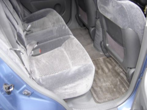 1999 Ford Taurus - The interior rear seats and floor mats of a blue vehicle are shown.
