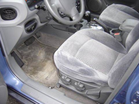 1999 Ford Taurus - The interior of a blue car is visible, including the driver's seat and dashboard.