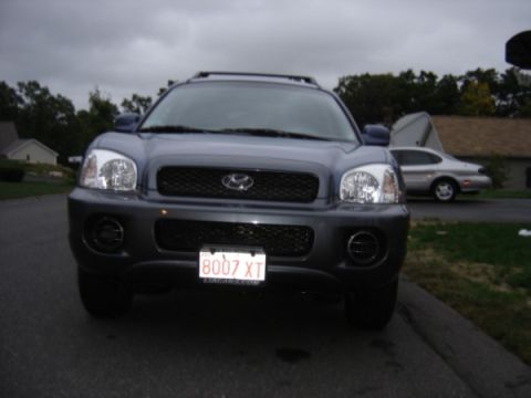 1999 Ford Taurus - A dark gray Hyundai Santa Fe is parked on an asphalt surface with a silver sedan in the background.