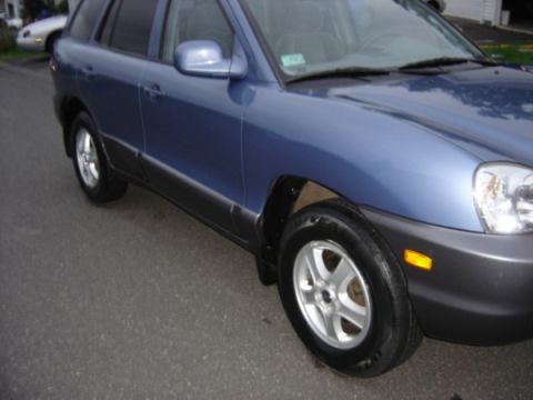 1999 Ford Taurus - This blue SUV is shown from the front 3/4 angle, with another vehicle in the background.