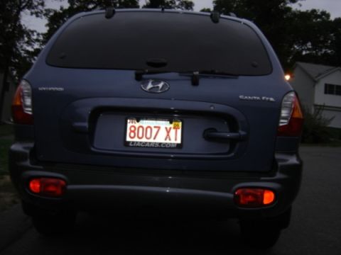 1999 Ford Taurus - The rear view of a blue Hyundai Santa Fe SUV is shown, with its license plate clearly visible.