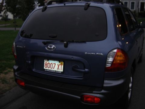 1999 Ford Taurus - The rear of a blue Hyundai Santa Fe SUV is shown, with a license plate and visible badging.