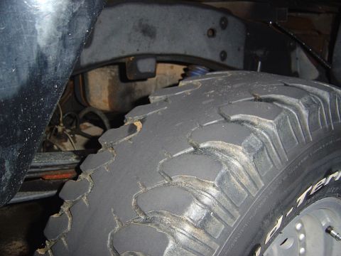1989 Ford Ranger - A close-up view of a heavily worn off-road tire and visible suspension components, suggesting off-road use.