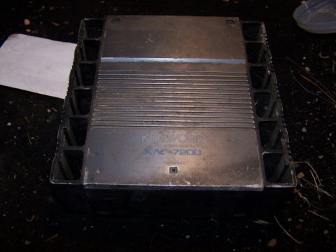1979 Ford F-150 - A Kenwood KAC-7200 car amplifier is shown from a top-down perspective, resting on a dark surface.