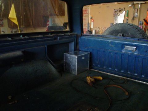 1984 Ford Bronco - The interior of a 1984 Ford Bronco, with a metal box and a drill visible.