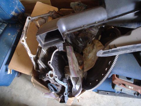 1984 Ford Bronco - Assorted engine components are piled together in a box.