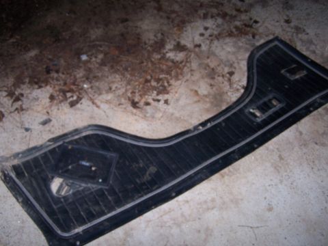 1979 Ford F-150 - A detached car door panel lies on a concrete floor with debris scattered around it.