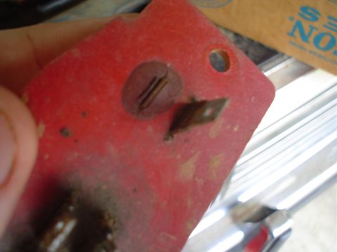 1984 Ford Bronco - A close-up view of a red plastic component with visible hardware and a metal accent.