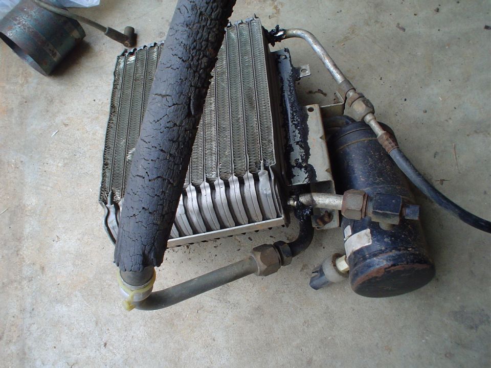 car AC condenser with a cracked hose and a receiver-drier unit
