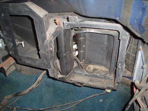 1984 Ford Bronco - The interior of a vehicle shows the disassembled HVAC system, revealing the ductwork and exposed wiring beneath the dashboard.