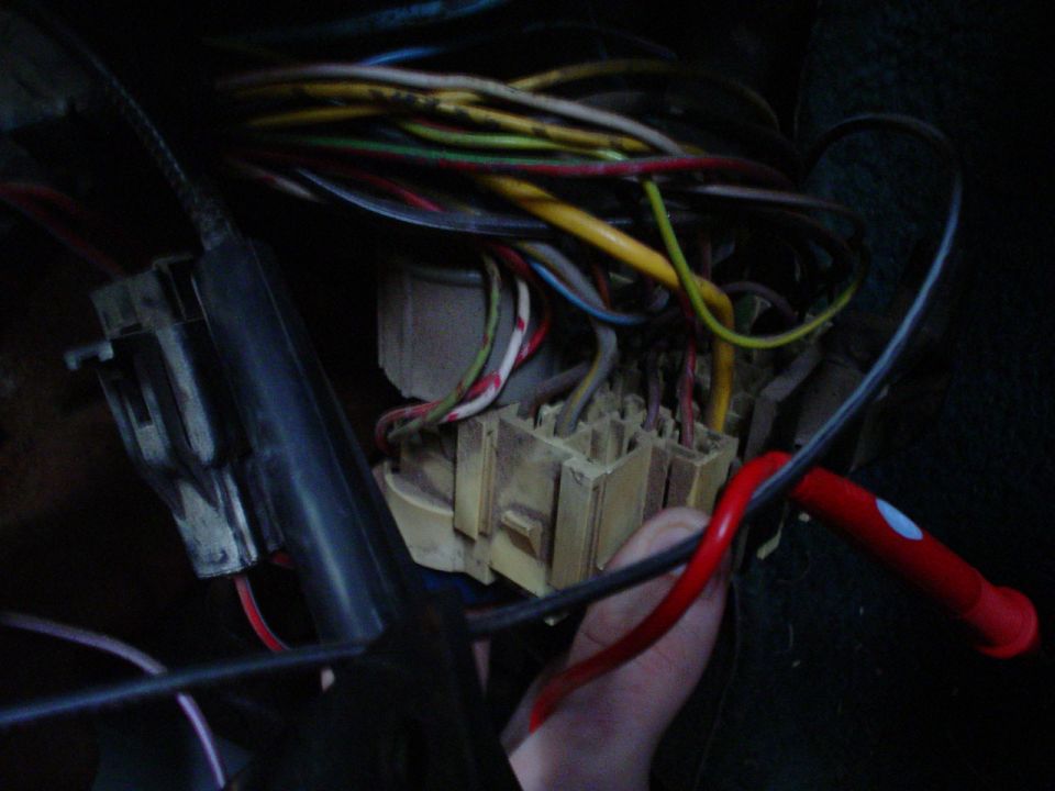 Close-up of a vehicle's interior wiring harness and fuse box