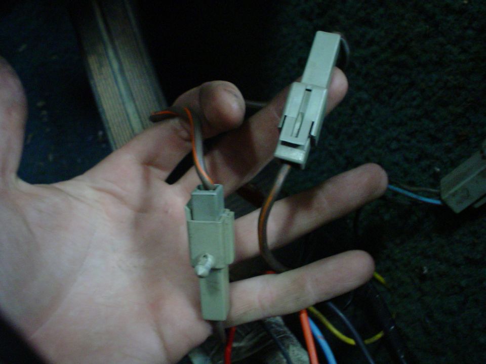 hand holding two electrical connectors with wires