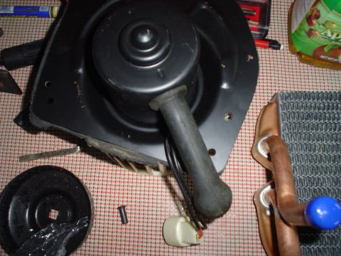 1984 Ford Bronco - A blower motor and heater core are laid out on a checkered surface, likely for an interior rebuild.