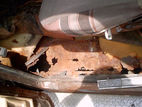 1979 Ford Bronco - The floor pan of this vehicle has severe rust damage, with large sections missing.