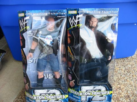 1991 Ford Bronco - Two WWF action figures, Stone Cold Steve Austin and The Undertaker, are displayed in their original packaging.