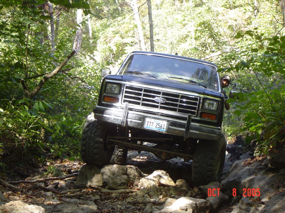 Black 1980s Ford Bronco navigating rocky trail