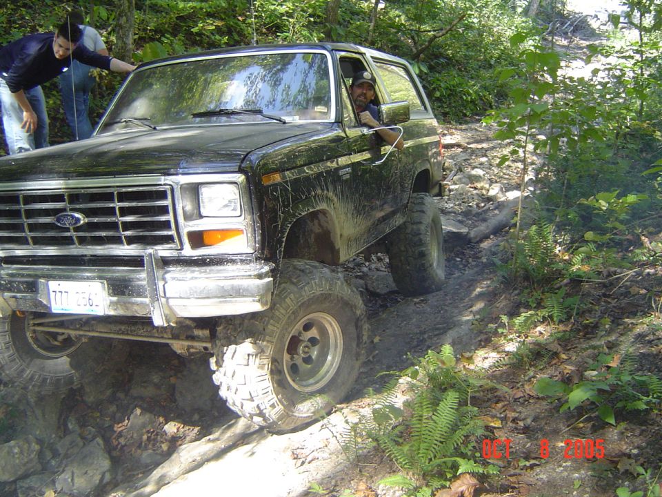 Black 1986 Ford Bronco navigating a rocky trail