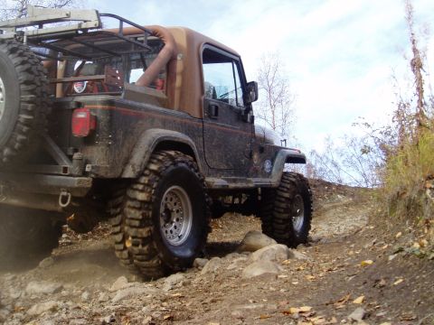 2000 Ford E350 - A Jeep Wrangler navigates a challenging, rocky off-road path.