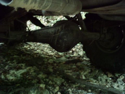 1986 Ford Bronco - The underside of a vehicle, focusing on the rear axle and exhaust system, is captured in this image.