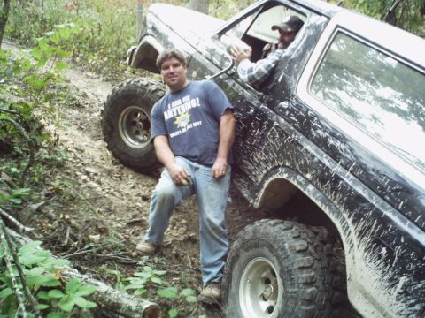 1986 Ford Bronco - A 1986 Ford Bronco navigates a challenging off-road trail with two occupants.