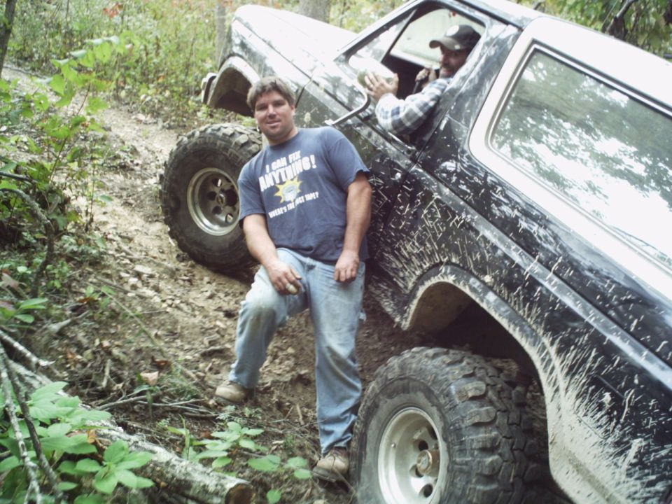 1986 Ford Bronco on a muddy trail with two men