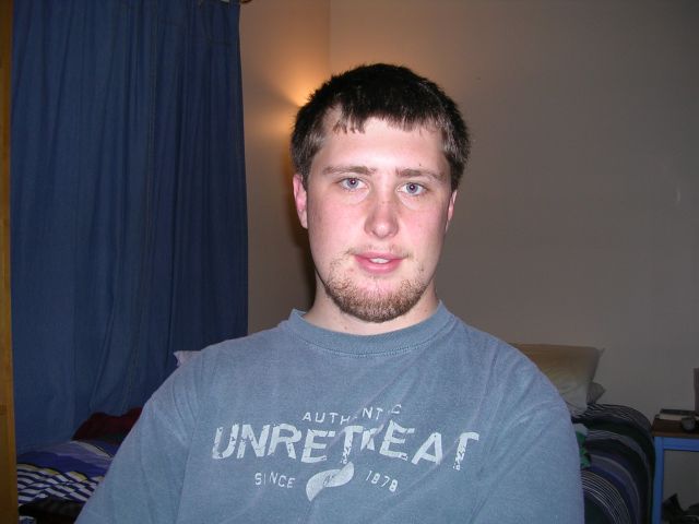 Man wearing a grey t-shirt with text, indoors