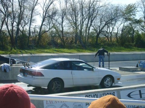 1992 Ford Probe - A white 1992 Ford Probe is positioned on a drag strip with a person standing on its hood.