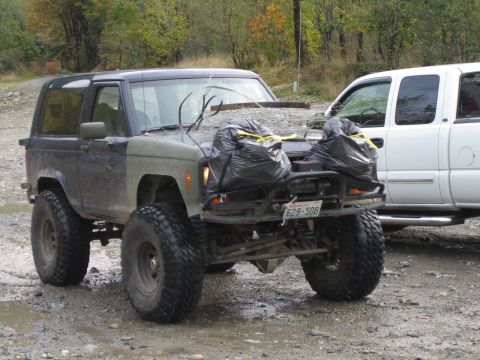 1990 Ford Bronco - This modified 1990 Ford Bronco features oversized tires and a unique hood adornment of trash bags filled with debris.
