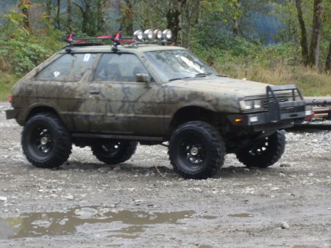 1990 Ford Bronco - This heavily modified Subaru hatchback is equipped for off-road adventures with its large tires and roof-mounted lights.