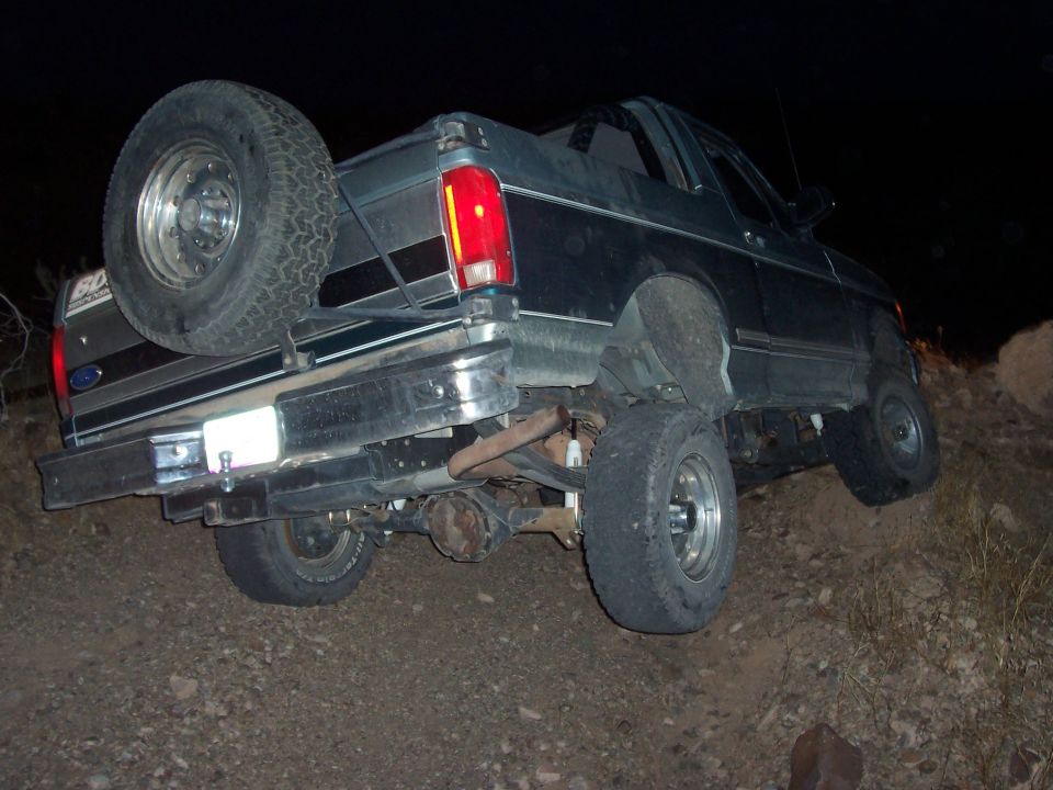 1996 Ford Bronco on uneven terrain, rear view with spare tire mounted