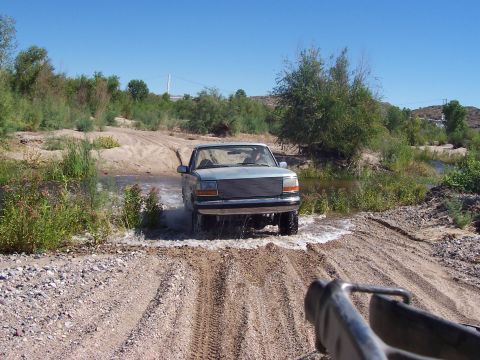 1996 Ford Bronco - Ford Bronco navigates a water crossing on a sunny day.