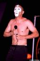 1991 Ford Bronco - Performer on stage wearing a white mask and holding a microphone.