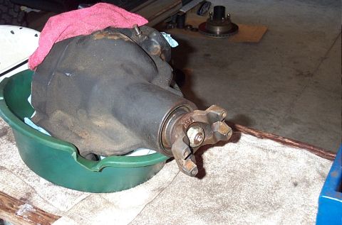 1995 Ford Bronco - A removed differential third-member/carrier with its pinion yoke still attached, set nose-down in a green oil drain pan on shop towels to d…