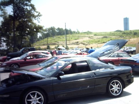 1995 Ford Probe - Several cars are parked in an outdoor lot, with a water tower visible in the background.