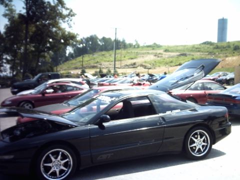 1995 Ford Probe - Several Ford Probes gathered, one with its hood open, under a bright sky.