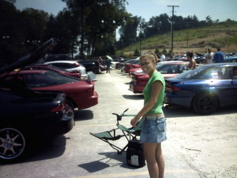 1995 Ford Probe - A woman stands in a parking lot filled with cars, including a blue 1995 Ford Probe.