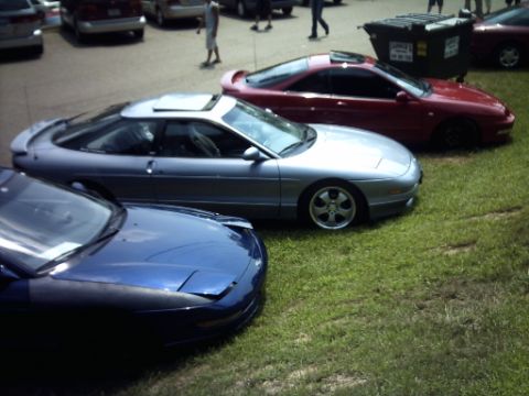1995 Ford Probe - A silver 1995 Ford Probe is parked on the grass next to other vehicles.