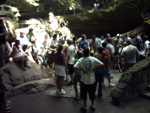 1995 Ford Probe - A crowd of people are exploring a scenic outdoor location with large rock formations and trees.