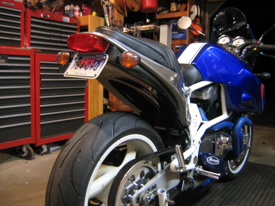 Rear of blue/white Buell motorcycle in garage with red tool chests and CT plate