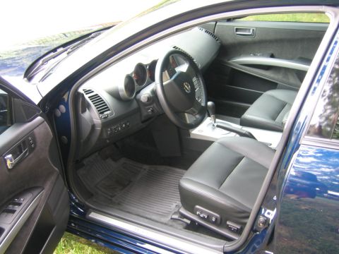 2005 Nissan Maxima - The interior of a blue sedan, showing the driver's seat, dashboard, and center console.