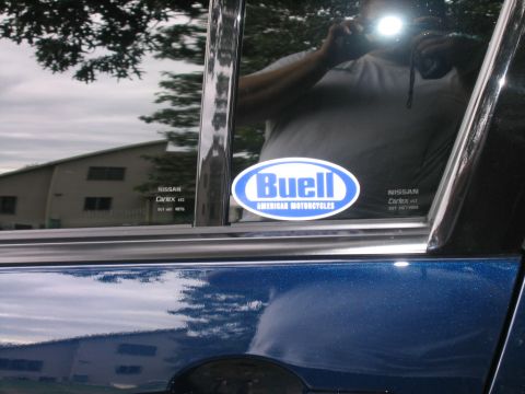 2005 Nissan Maxima - Car window shows a Buell sticker and some text, with a reflection of the photographer.
