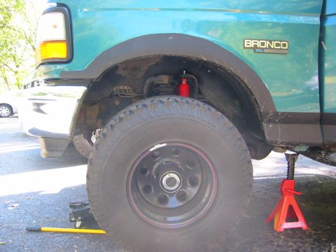 1996 Ford Bronco - Close-up of the suspension on a 1996 Ford Bronco XL, highlighting a red shock absorber.