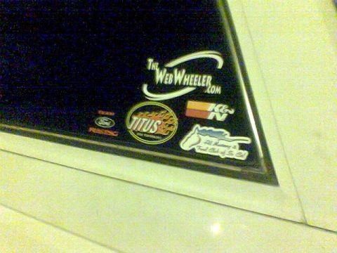 1988 Ford Bronco - A collection of decals adorns a vehicle's window, various brands and club affiliations.