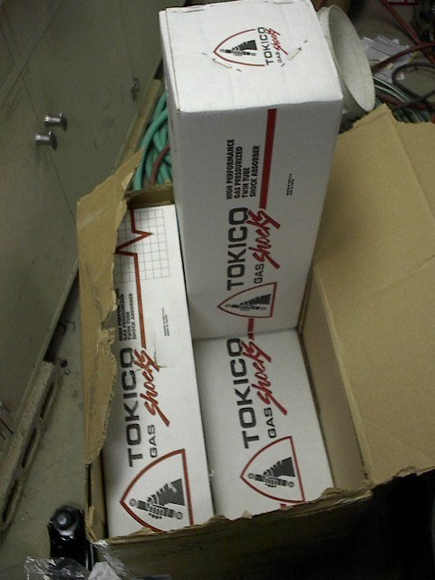 1993 Ford Probe - Tokico gas shocks are packaged in a cardboard box, with some of the packaging torn.