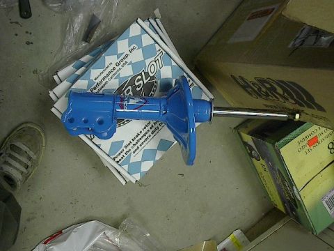 1993 Ford Probe - A blue performance strut is shown resting on a stack of boxes, one of which is branded 'Power Slot'.