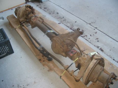 1991 Ford Bronco - Front axle assembly, likely from a truck or SUV, is shown disassembled and mounted on wooden planks.