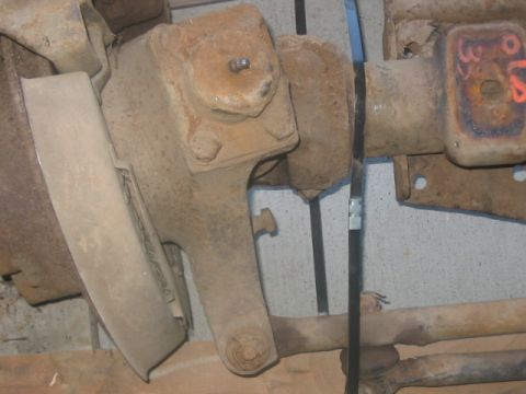 1991 Ford Bronco - Close-up view of heavily rusted vehicle axle and suspension components, with some visible markings.