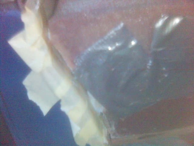 Close-up of a dark car interior with blue fabric and yellow tape