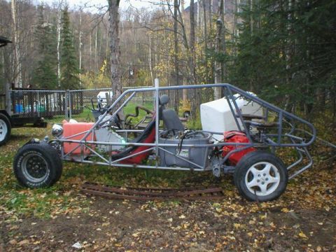 2003 Jeep TJ - Custom dune buggy frame with exposed engine and roll cage, parked outdoors.