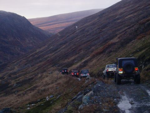 2000 Ford E350 - A convoy of SUVs and a pickup truck navigates a rough mountain road.